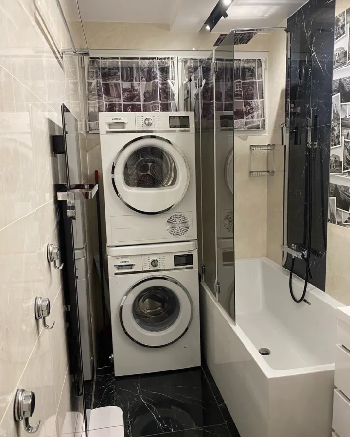 Salle de bain avec baignoire et colonne lave-linge intégrée