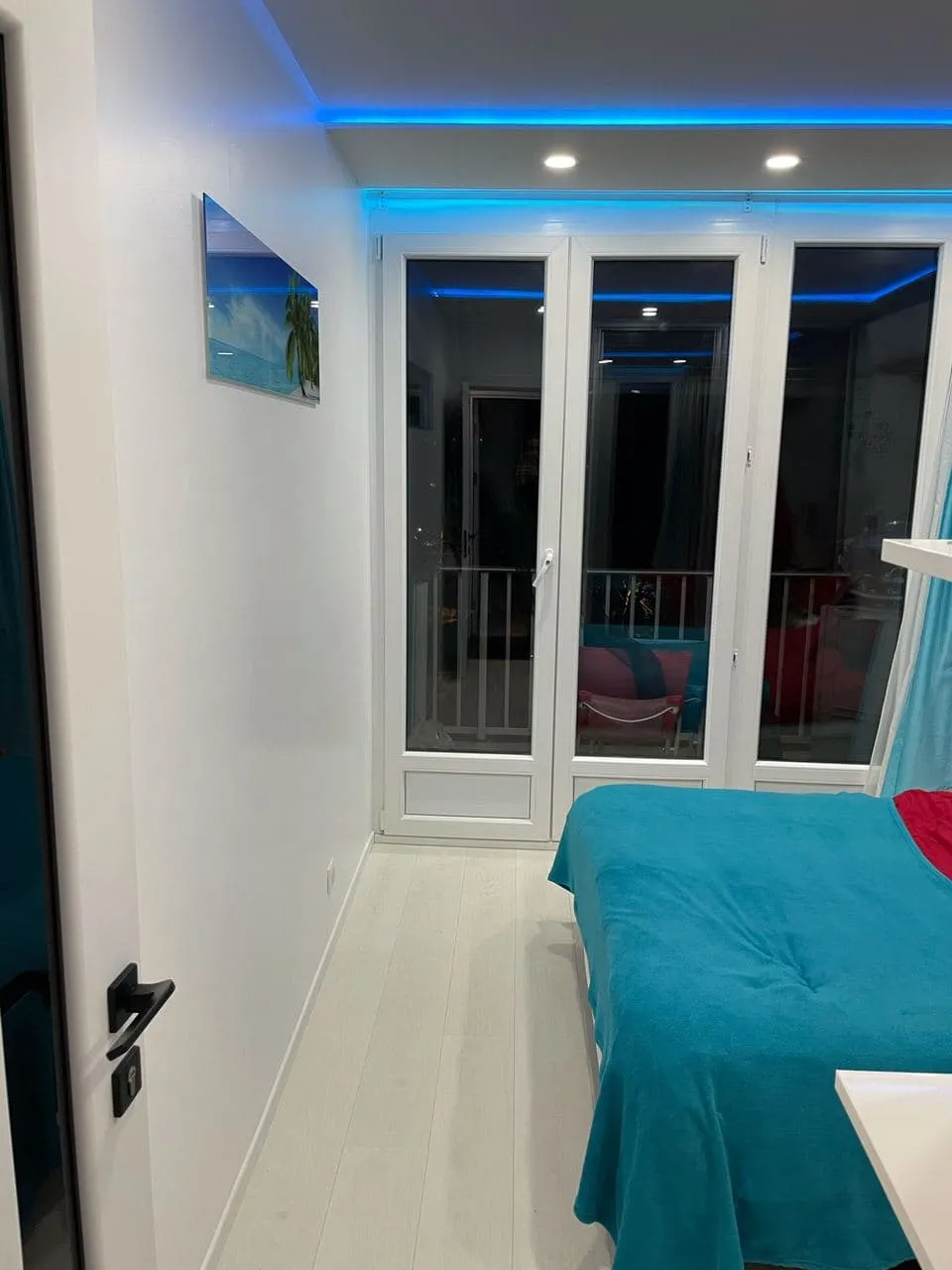 La même pièce après rénovation : murs blancs, sol clair et éclairage LED indirect