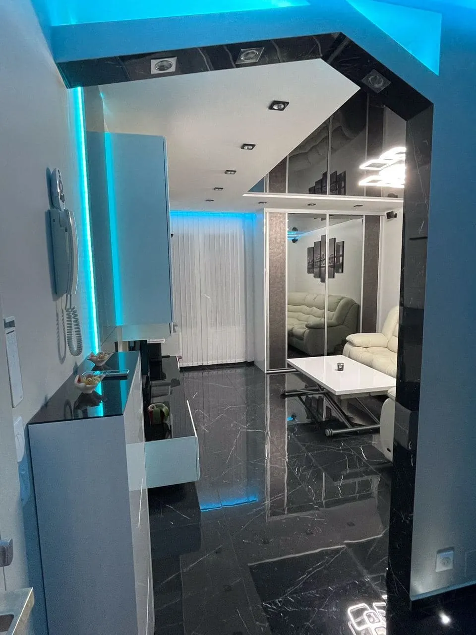 Séjour rénové avec sol effet marbre et plafond lumineux à LED